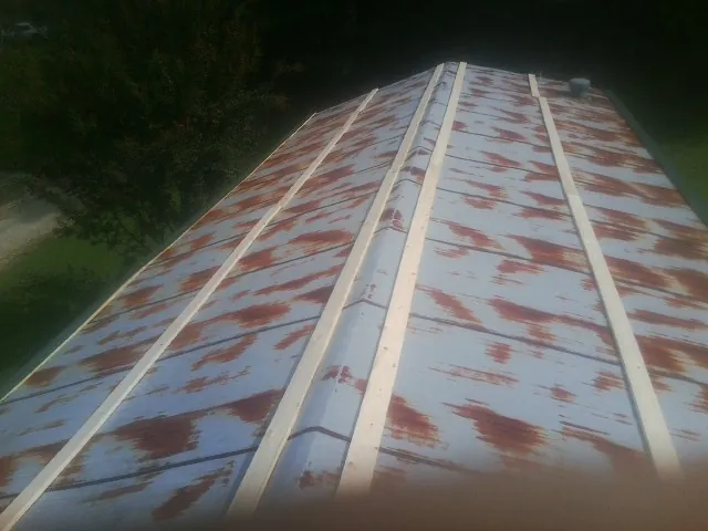 Rusted metal roof panels with new wood purlins before replacement — Storm Damage Roof Repair in Belford by Roofing Brothers