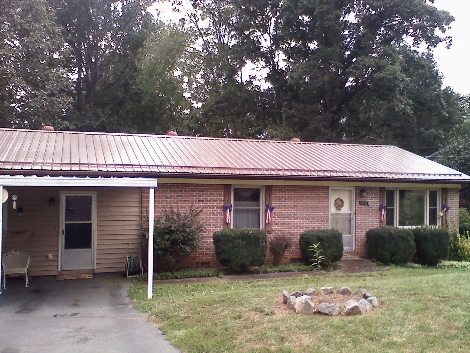 Bronze metal roof and carport on a brick ranch home — Roof Repair work by our crew in Belford